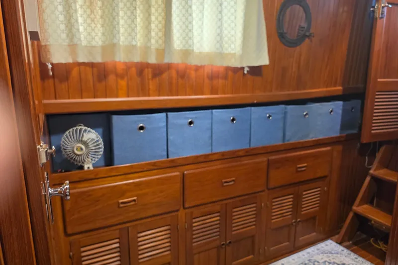 Slide: The Image of Wooden interior of 1983 Monk 36 boat with storage bins and a small fan. - 21