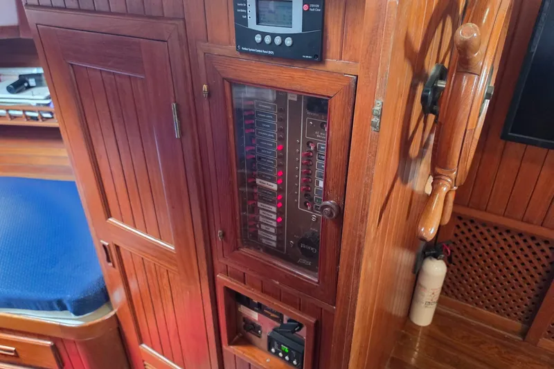 Slide: The Image of Wooden control panel on a 1983 Monk 36 boat, featuring switches and gauges. - 16