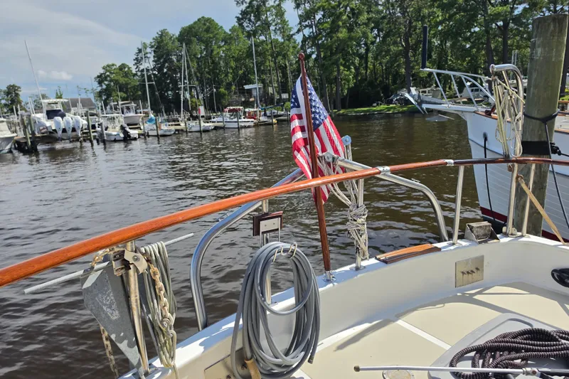 Slide: The Image of Cockpit view of 1983 Monk 36 boat docked at a marina with American flag. - 2