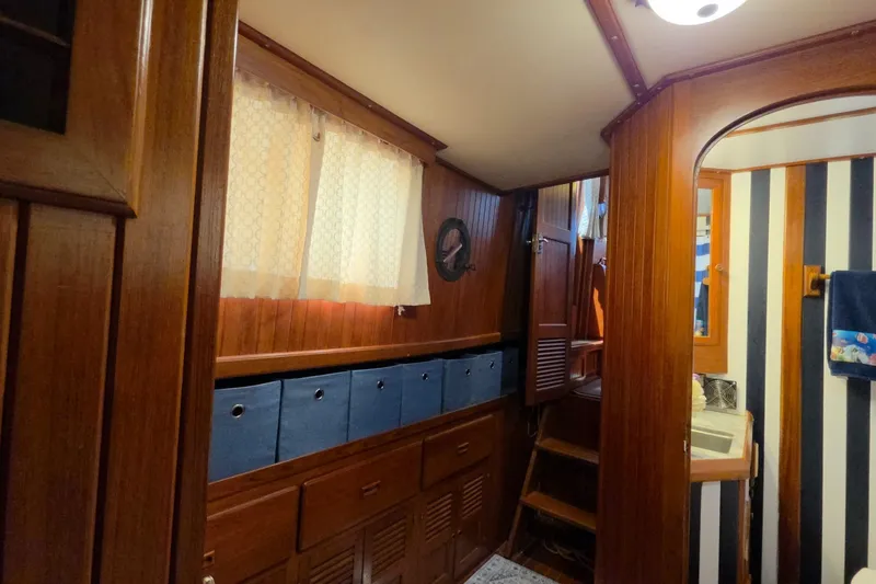 Slide: The Image of Interior of 1983 Monk 36 boat with wooden cabinetry and striped wall decor. - 22