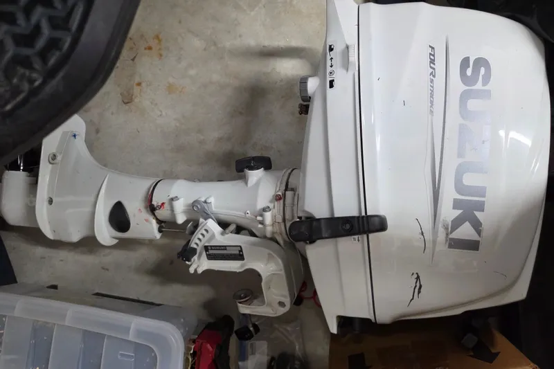 Slide: The Image of White Suzuki outboard motor, four-stroke engine, on a garage floor. - 28