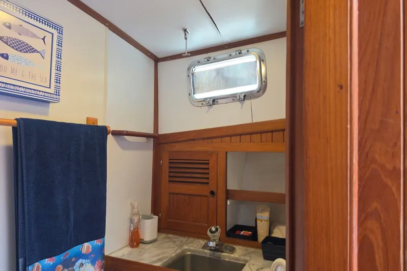 Slide: The Image of Wood-paneled bathroom in 1983 Monk 36 boat with sink, towel, and nautical decor. - 10