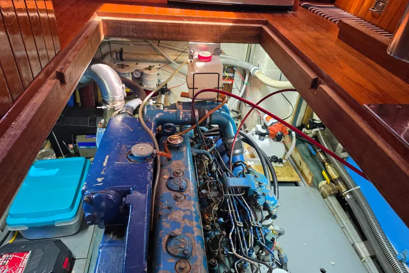 Slide: The Image of Engine room of a 1983 Monk 36 boat with visible blue engine components. - 26