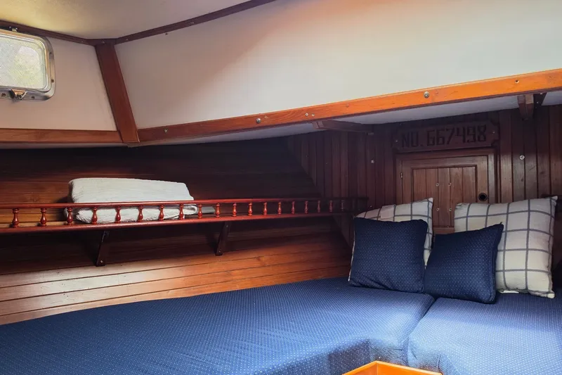 Slide: The Image of Cozy cabin interior of 1983 Monk 36 boat with wooden paneling and blue cushions. - 8