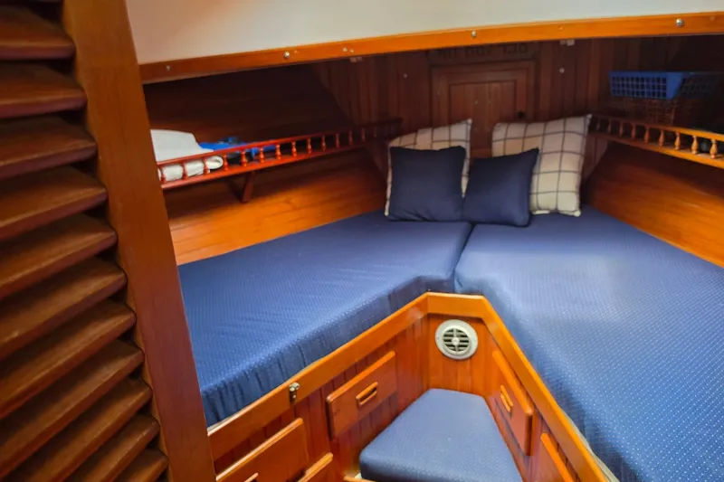 Slide: The Image of Cozy cabin interior of 1983 Monk 36 boat with blue bedding and wooden finish. - 15