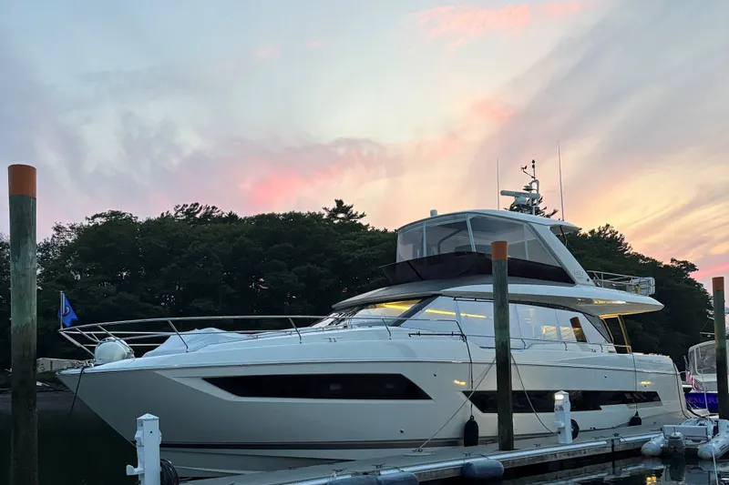The Image of Luxury 2023 Prestige 690 yacht docked at sunset with scenic sky backdrop. - 0
