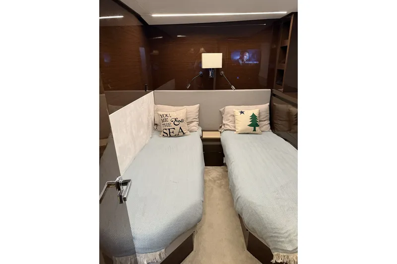 Slide: The Image of Luxurious twin cabin interior of 2023 Prestige 690 yacht with decorative pillows. - 35