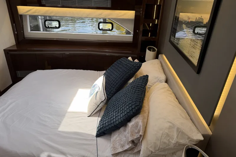 Slide: The Image of Luxurious bedroom interior of 2023 Prestige 690 yacht with elegant bedding and window view. - 26