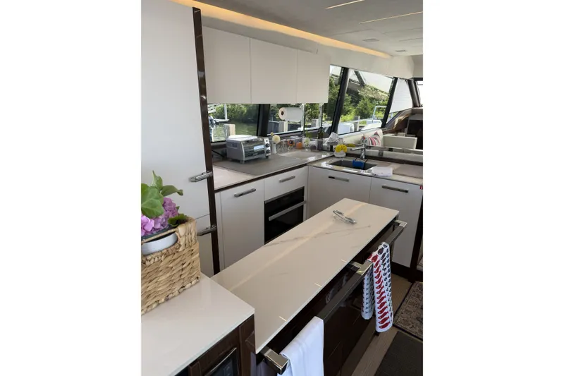 Slide: The Image of Modern kitchen interior on 2023 Prestige 690 yacht, featuring sleek countertops and appliances. - 18