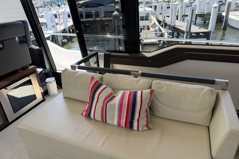 Slide: The Image of Luxurious interior of 2023 Prestige 690 yacht with striped pillow and marina view. - 21