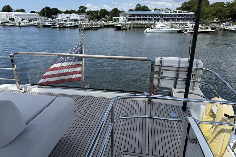 Slide: The Image of Deck view of 2023 Prestige 690 yacht with American flag at marina. - 15