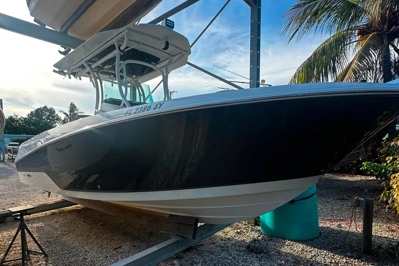 The Image of 2021 Wellcraft 262 Fisherman boat on a rack, surrounded by palm trees and clear sky. - 0