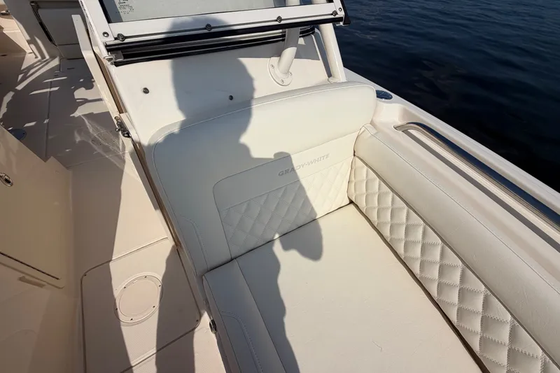 Slide: The Image of 2025 Grady-White Freedom 235 boat interior with quilted white seating near water. - 14