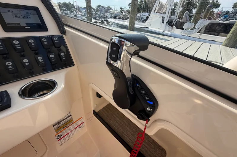 Slide: The Image of Control panel of 2025 Grady-White Freedom 235 boat, featuring throttle and switches. - 23