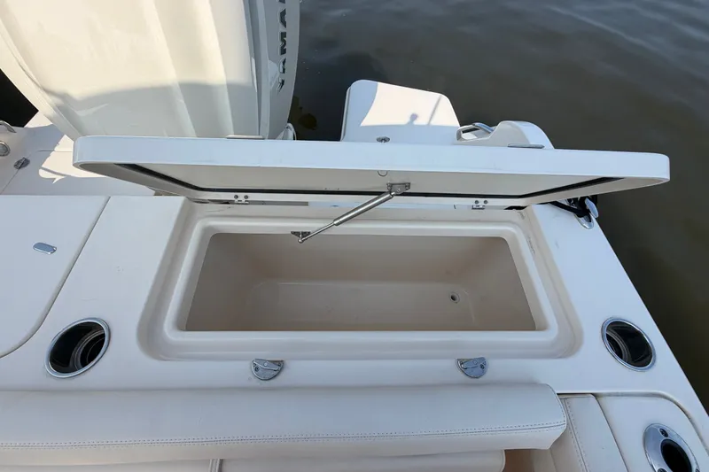 Slide: The Image of Open storage compartment on 2025 Grady-White Freedom 235 boat, near water. - 34