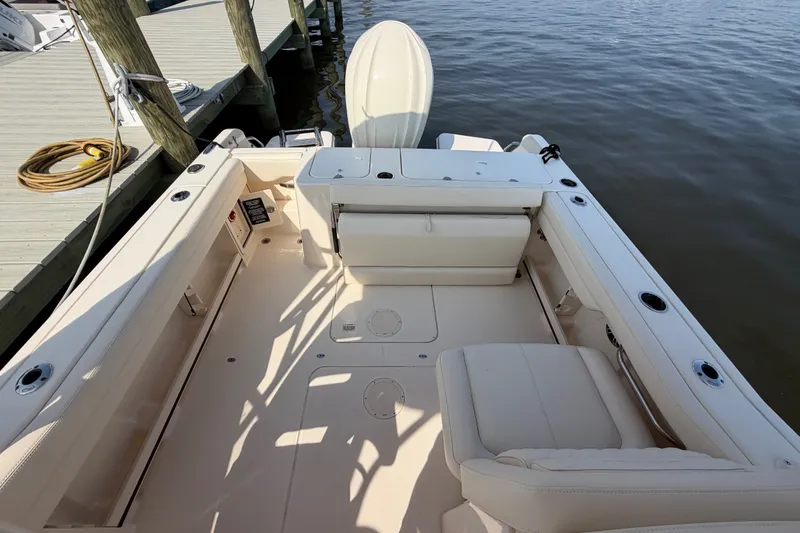 Slide: The Image of 2025 Grady-White Freedom 235 boat interior at dock, showcasing spacious seating and storage. - 28
