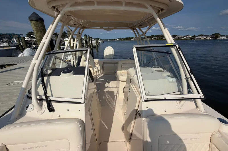 Slide: The Image of 2025 Grady-White Freedom 235 boat interior at dock, showcasing seating and helm area. - 16