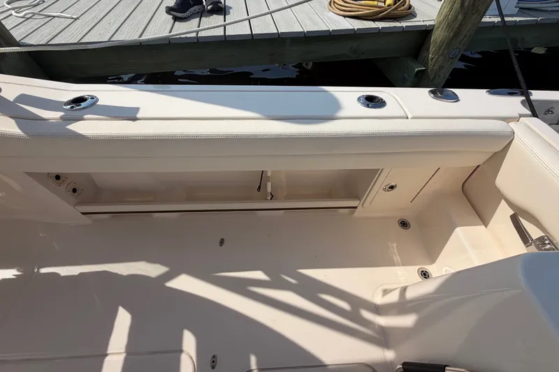 Slide: The Image of 2025 Grady-White Freedom 235 boat interior with seating and storage, dockside view. - 32