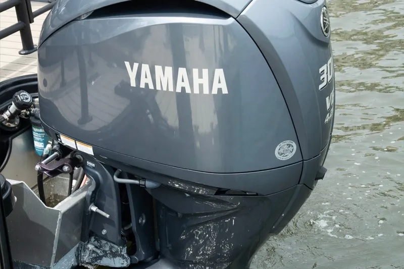 Slide: The Image of Yamaha outboard motor on 2023 Sylvan L5 DLZ Bar boat, docked by water. - 3