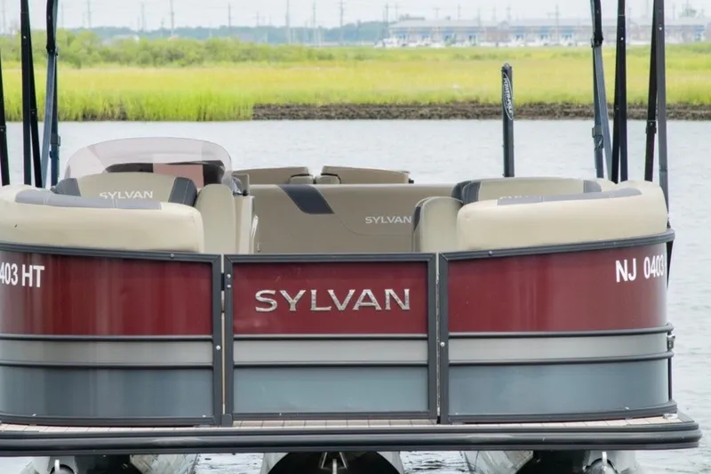 Slide: The Image of 2023 Sylvan L5 DLZ Bar pontoon boat on water, rear view. - 2