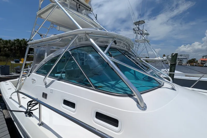Slide: The Image of 2005 Rampage 38 Express boat docked under a clear blue sky. - 12