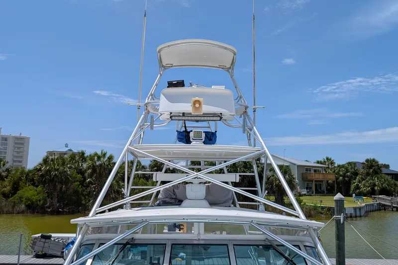 Slide: The Image of 2005 Rampage 38 Express boat with tower, docked near waterfront homes. - 6