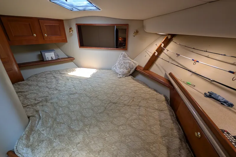 Slide: The Image of Cozy cabin interior of 2005 Rampage 38 Express with bed and fishing rods. - 27