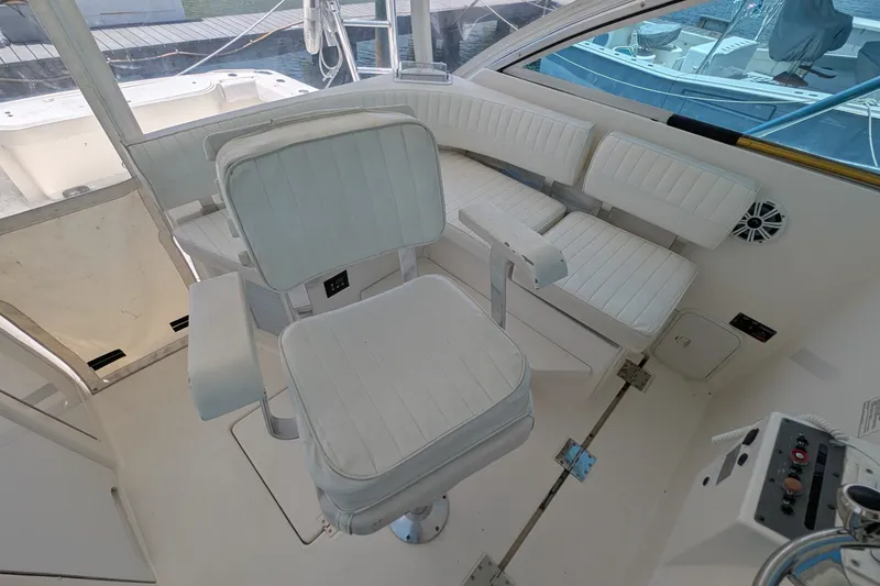 Slide: The Image of 2005 Rampage 38 Express boat interior with white seating and helm chair. - 15