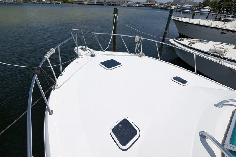 Slide: The Image of 2005 Rampage 38 Express boat docked at marina, showing bow and deck details. - 11