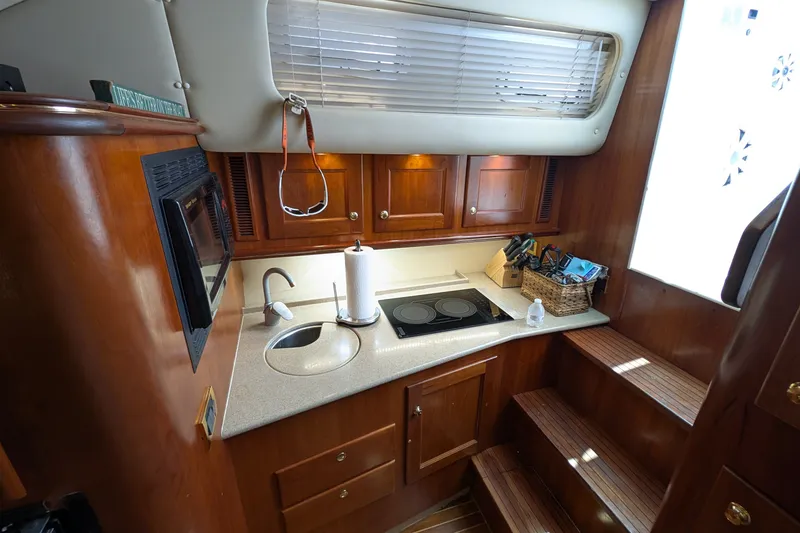 Slide: The Image of 2005 Rampage 38 Express yacht kitchen with wooden cabinets, sink, and stovetop. - 26