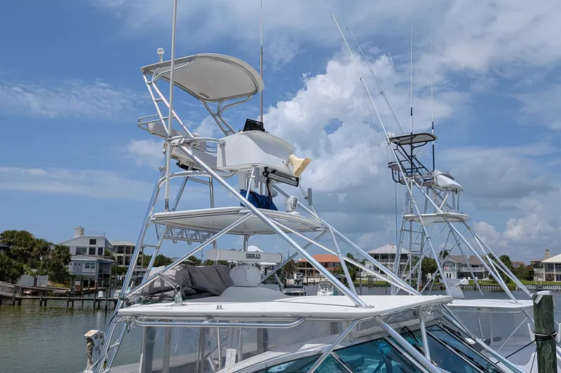 Slide: The Image of 2005 Rampage 38 Express boat with tower, docked in a marina under a blue sky. - 5