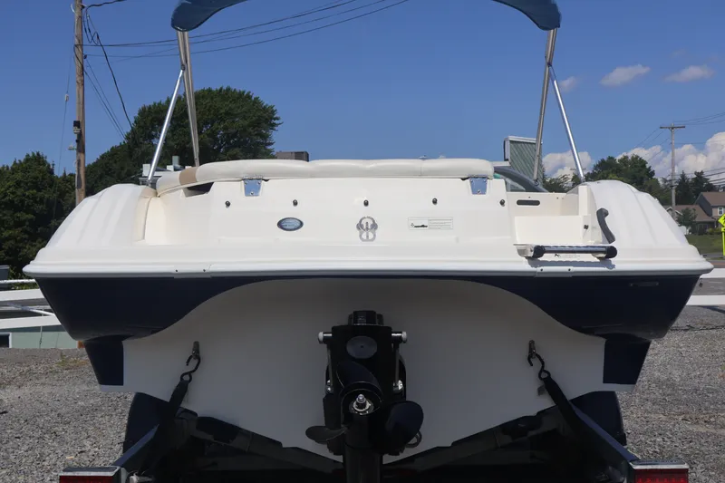 Slide: The Image of 2012 Larson LX 2150 boat rear view with canopy, parked on gravel. - 9