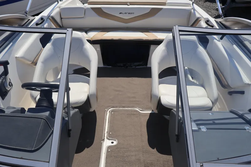 Slide: The Image of Interior of a 2012 Larson LX 2150 boat with white seating and steering wheel. - 26