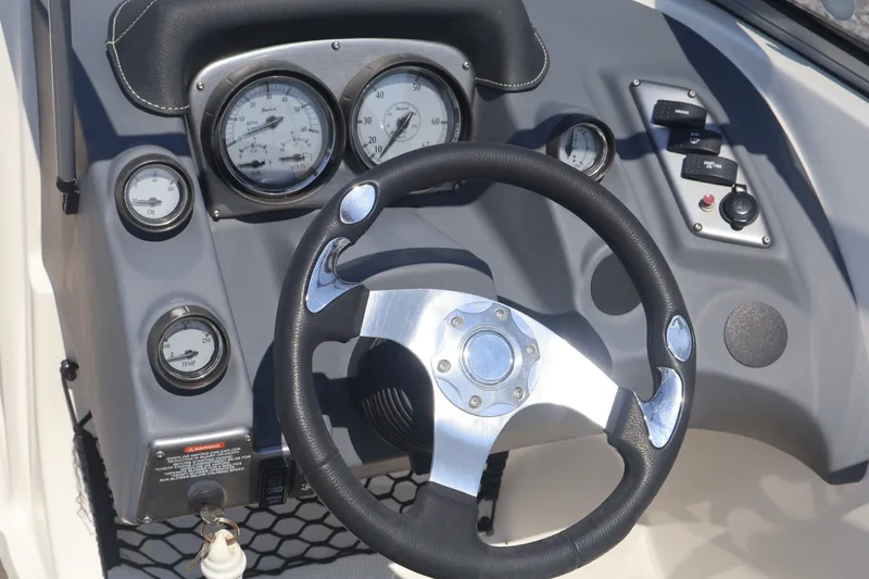 Slide: The Image of Steering wheel and dashboard of a 2012 Larson LX 2150 boat, featuring gauges and controls. - 29