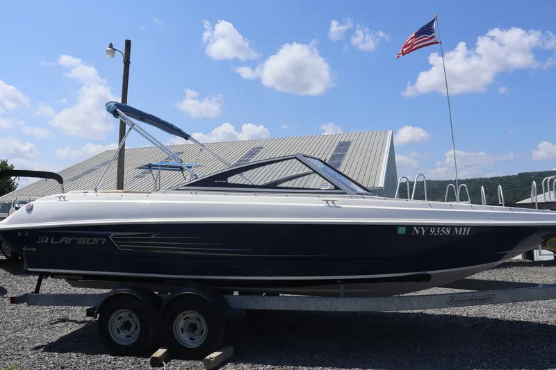 Slide: The Image of 2012 Larson LX 2150 boat on trailer, American flag in background. - 6