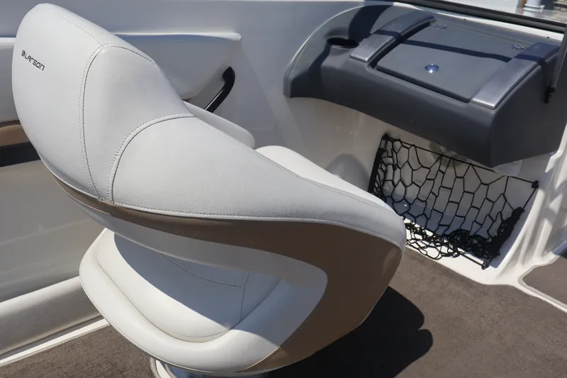 Slide: The Image of 2012 Larson LX 2150 boat interior with white captain's chair and storage net. - 24