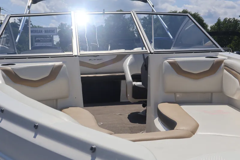 Slide: The Image of 2012 Larson LX 2150 boat interior with beige and white seating, sunny day. - 2