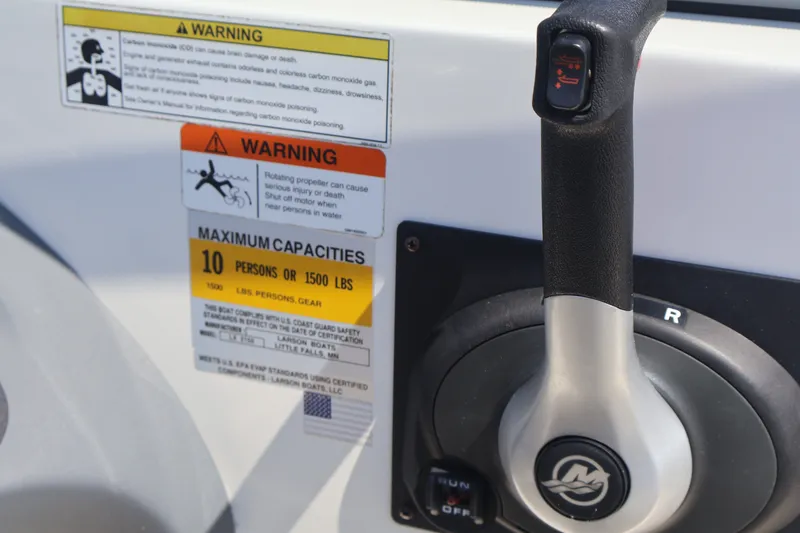 Slide: The Image of Throttle control and warning labels on a 2012 Larson LX 2150 boat. - 31