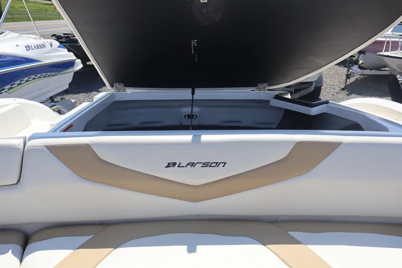 Slide: The Image of 2012 Larson LX 2150 boat with open storage compartment, beige and white interior. - 21