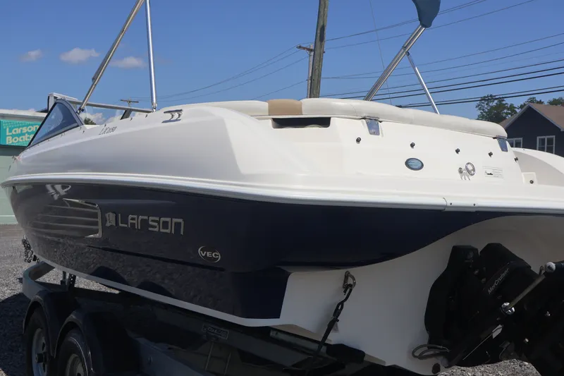 Slide: The Image of 2012 Larson LX 2150 boat with sleek design, displayed on a trailer under clear skies. - 10