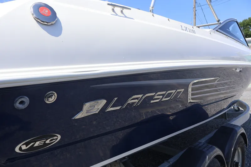 Slide: The Image of 2012 Larson LX 2150 boat side view with logo and VEC emblem. - 8