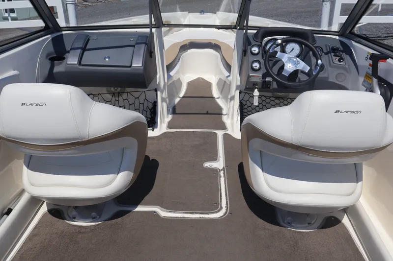 Slide: The Image of Interior of a 2012 Larson LX 2150 boat with dual white seats and steering console. - 23