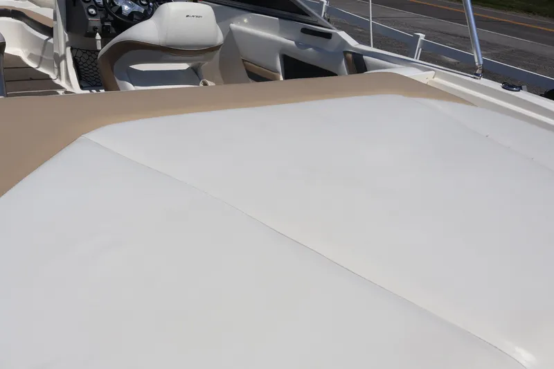 Slide: The Image of Interior view of a 2012 Larson LX 2150 boat, featuring beige and white seating. - 15
