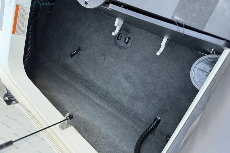 Slide: The Image of Interior storage compartment of a 2011 MasterCraft X-35 boat, featuring carpeted flooring. - 18