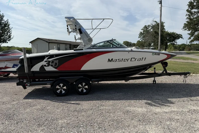 The Image of 2011 MasterCraft X-35 boat on trailer, side view, parked outdoors. - 1