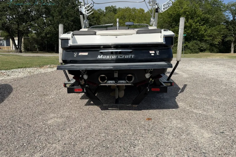 Slide: The Image of Rear view of a 2011 MasterCraft X-35 boat on a gravel surface. - 4