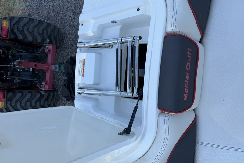 Slide: The Image of 2011 MasterCraft X-35 boat ladder and seating detail with tractor in background. - 27