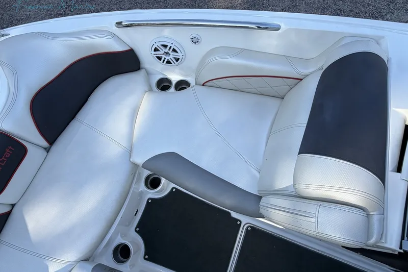 Slide: The Image of 2011 MasterCraft X-35 boat interior with white and black seating, cup holders, and speaker. - 25