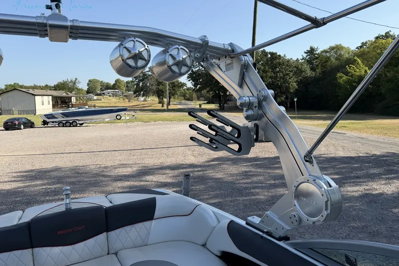 Slide: The Image of 2011 MasterCraft X-35 boat with wakeboard tower and speakers, parked outdoors. - 34