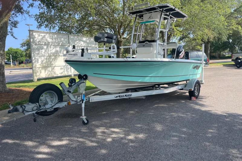 The Image of 2019 Mako 19 CPX boat on trailer, parked outdoors under trees. - 0